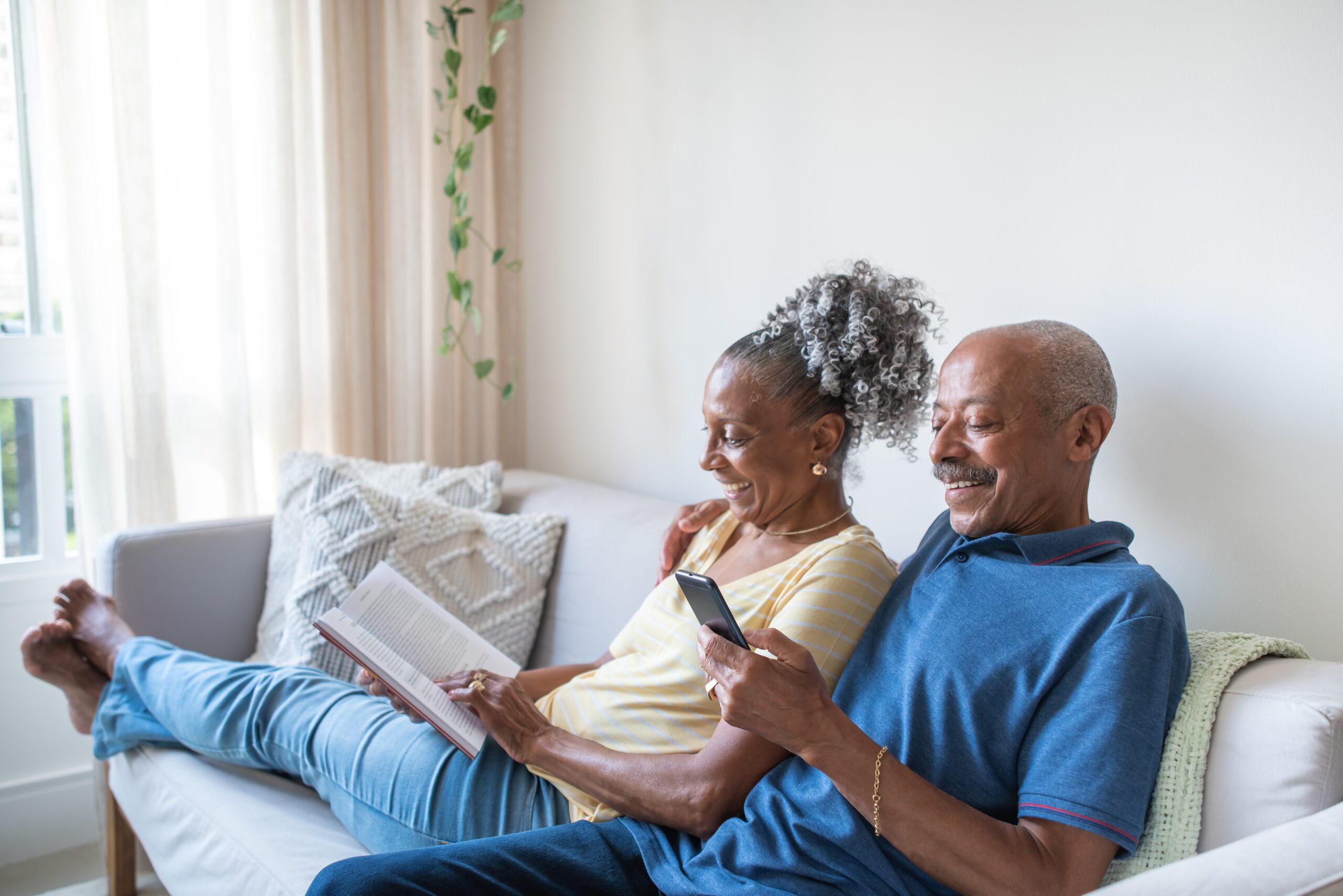 Retired senior couple sitting on home sofa